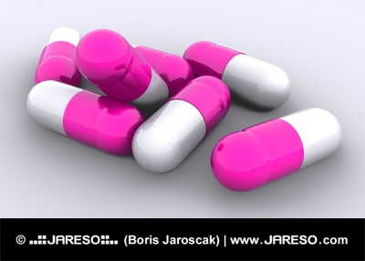 Nærbillede af syv lyserøde piller isoleret på den hvide baggrund
