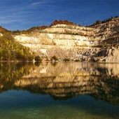 Herbstspiegelung eines felsigen Hügels im Sutovo-See, Slowakei