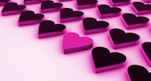 Un corazón rosa entre muchos corazones negros