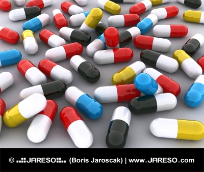 Molte pillole colorate su sfondo bianco