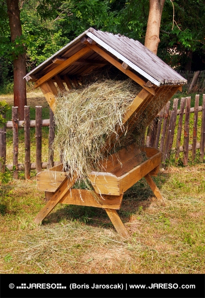Закрытая деревянная кормушка, полностью наполненная сеном